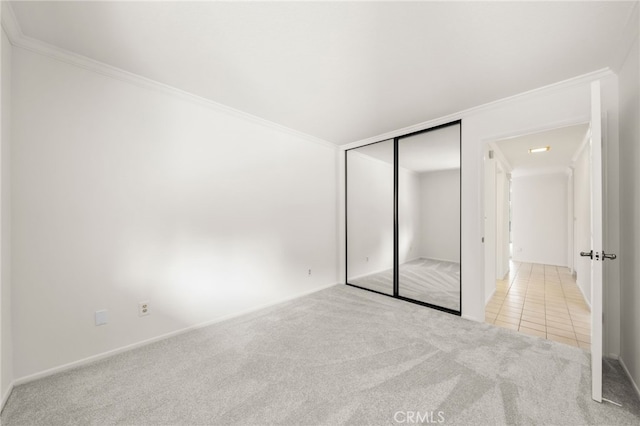 unfurnished bedroom with light carpet, a closet, and ornamental molding