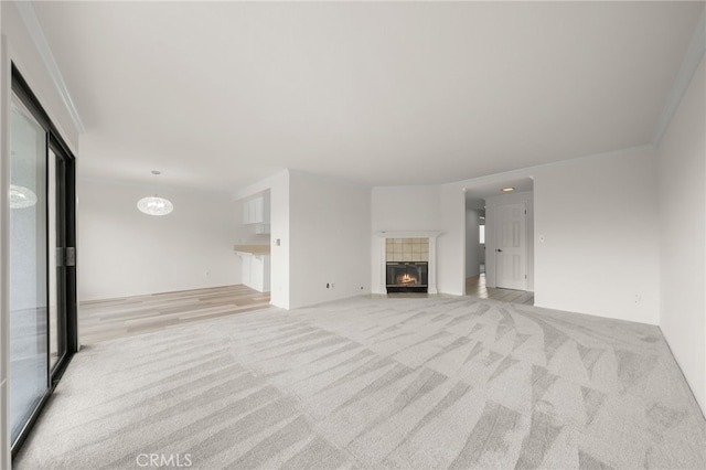 unfurnished living room featuring a fireplace, light carpet, and ornamental molding