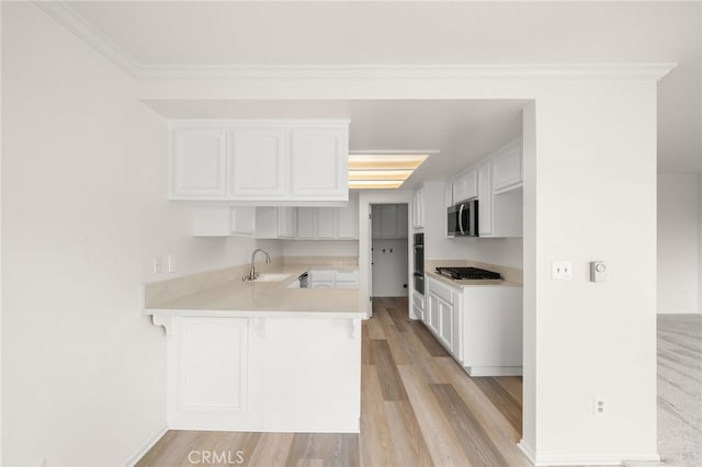 kitchen with sink, white cabinetry, appliances with stainless steel finishes, and kitchen peninsula