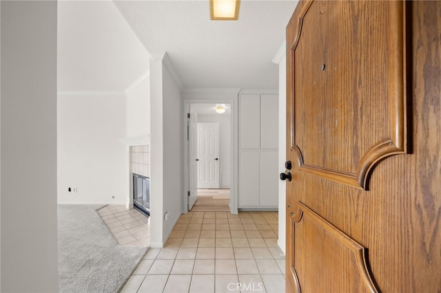 corridor featuring light tile patterned floors and crown molding