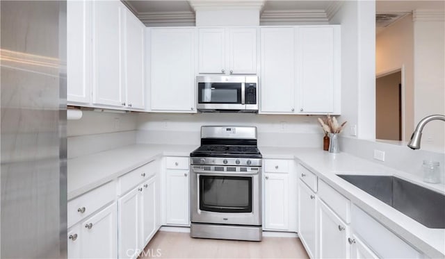 kitchen with sink, stainless steel appliances, and white cabinets