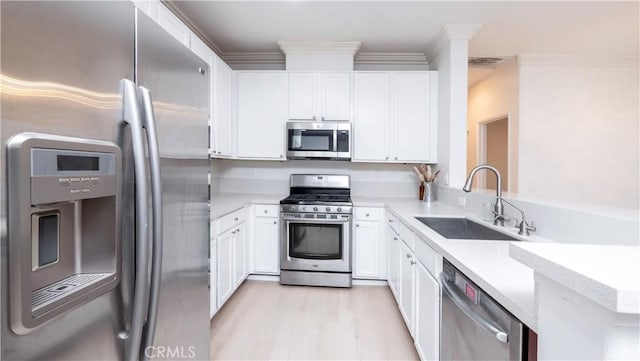 kitchen with stainless steel appliances, white cabinetry, and sink