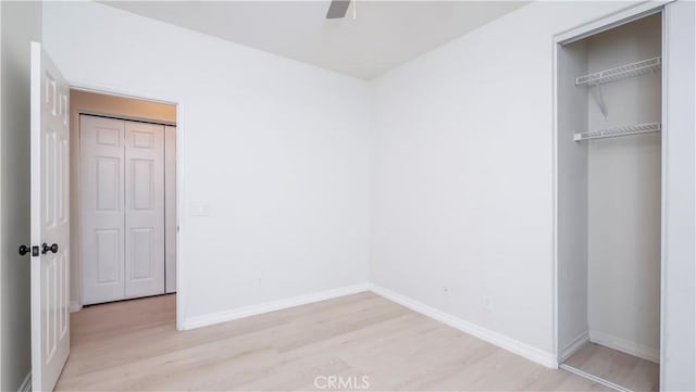 unfurnished bedroom with ceiling fan and light wood-type flooring