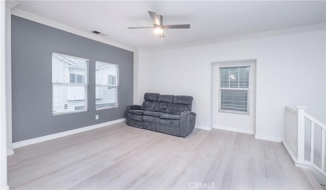 living area with crown molding, ceiling fan, and light wood-type flooring