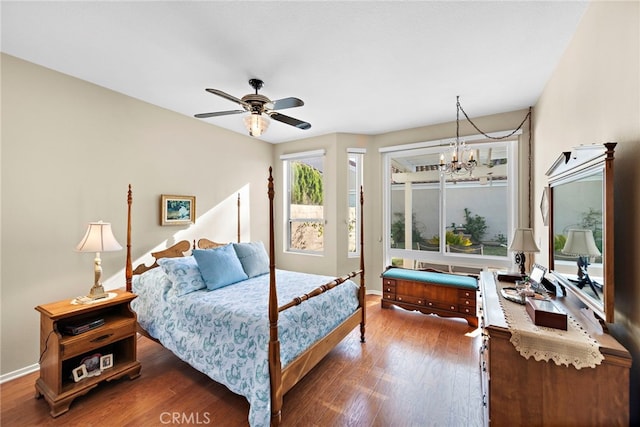 bedroom featuring ceiling fan with notable chandelier and dark hardwood / wood-style flooring