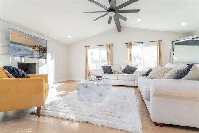 living room with light wood-type flooring, lofted ceiling with beams, and ceiling fan