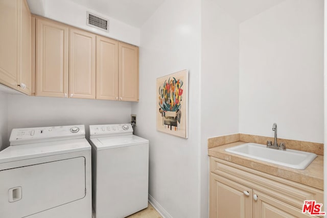 laundry area with sink, separate washer and dryer, and cabinets