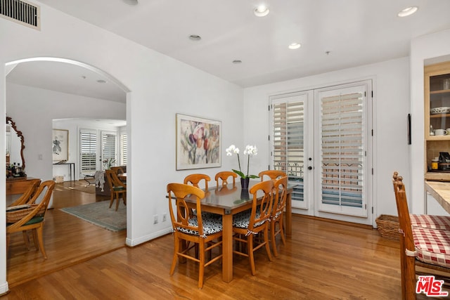 dining area with french doors and light hardwood / wood-style flooring