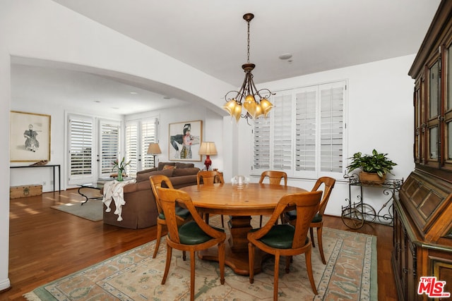 dining area featuring dark wood-type flooring and a chandelier