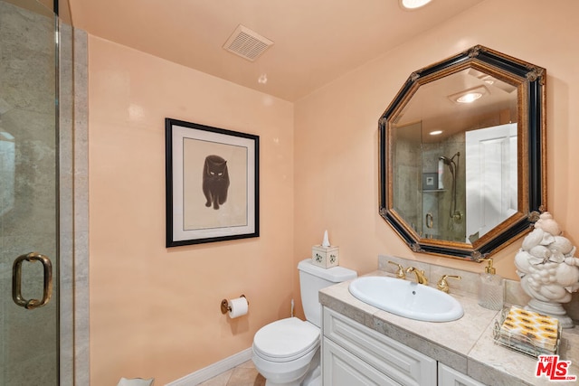 bathroom featuring vanity, toilet, tile patterned floors, and a shower with shower door