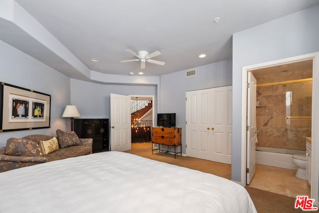 bedroom featuring light colored carpet, a closet, ensuite bath, and ceiling fan