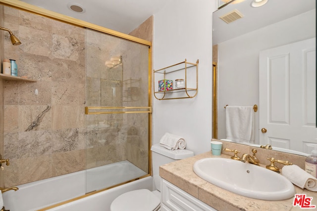 full bathroom featuring bath / shower combo with glass door, toilet, and vanity