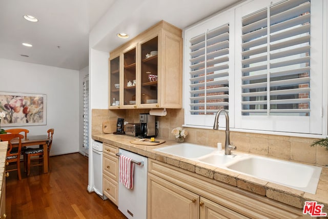 kitchen featuring light brown cabinetry, dishwasher, dark hardwood / wood-style flooring, sink, and decorative backsplash