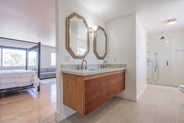 bathroom with wood-type flooring, walk in shower, and vanity