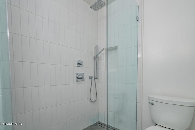 bathroom featuring toilet and tiled shower