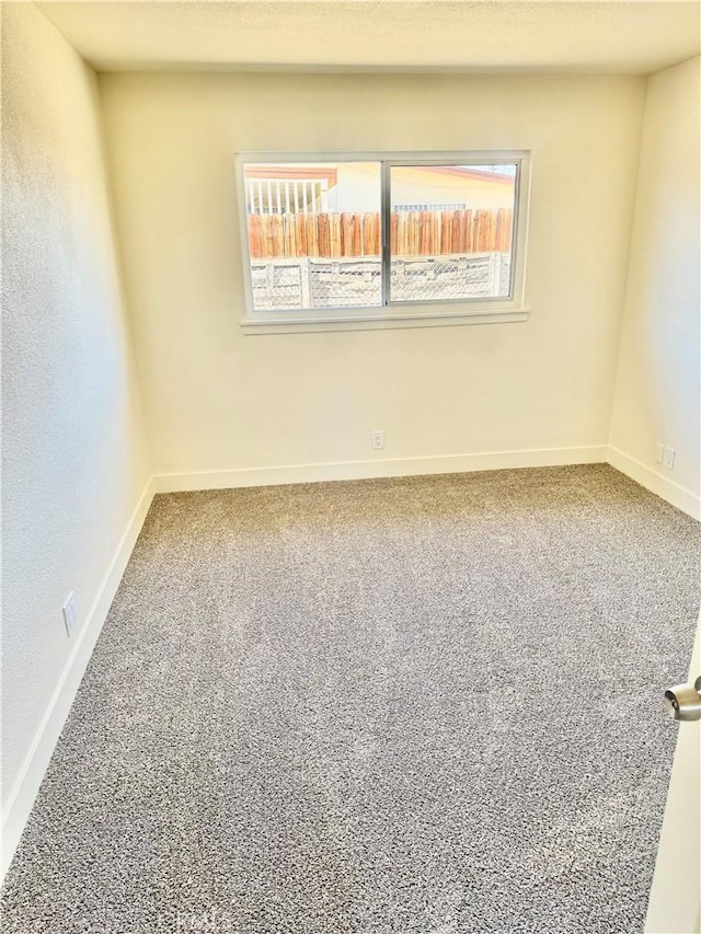 carpeted spare room with plenty of natural light and baseboards