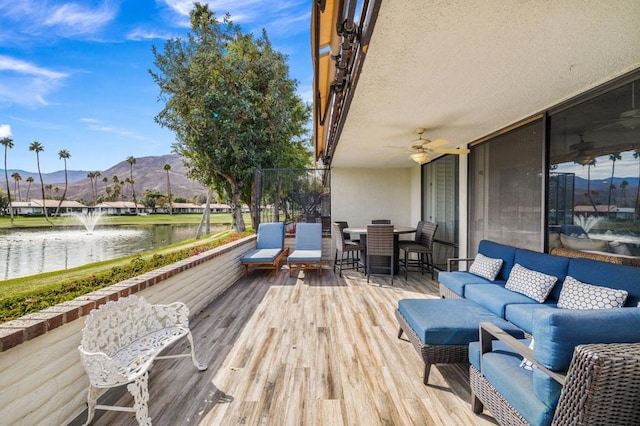 wooden terrace featuring a water and mountain view and outdoor lounge area