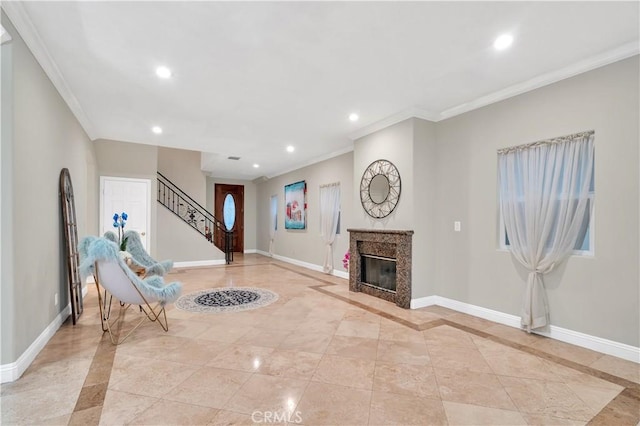 entryway featuring a high end fireplace and ornamental molding