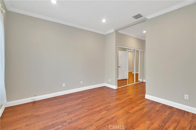 unfurnished room featuring hardwood / wood-style floors and crown molding