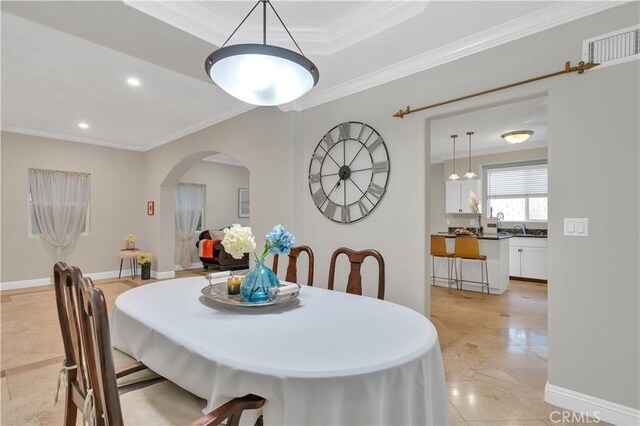 dining room featuring a tray ceiling and ornamental molding