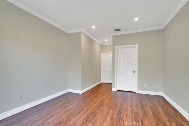 spare room featuring ornamental molding and dark hardwood / wood-style flooring