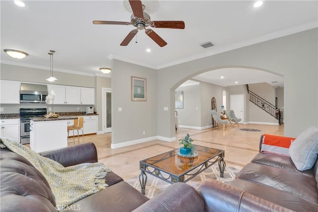 tiled living room with ceiling fan and crown molding