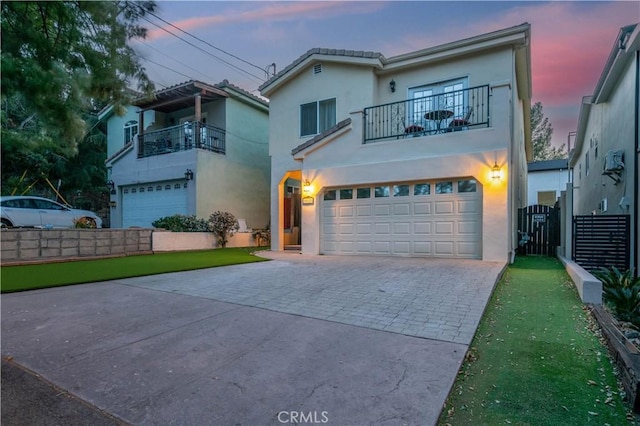 view of front of home with a balcony, a lawn, and a garage