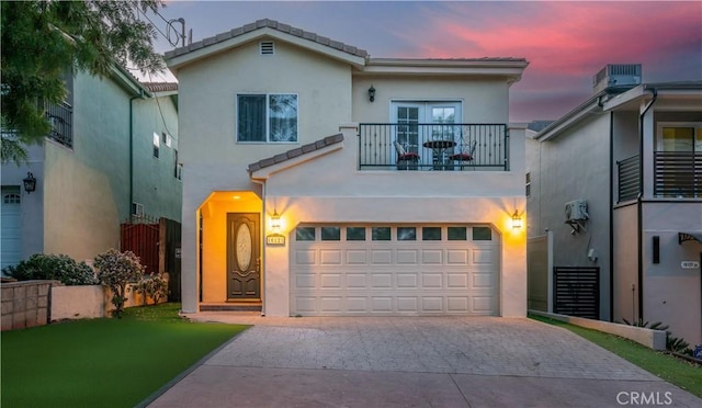 view of front of property featuring a balcony and a garage