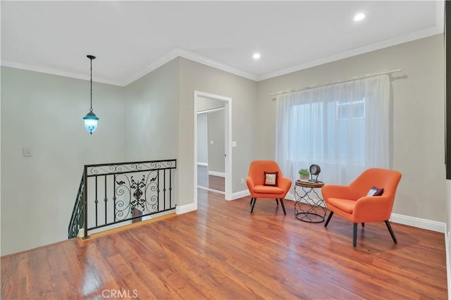 living area with hardwood / wood-style floors and ornamental molding