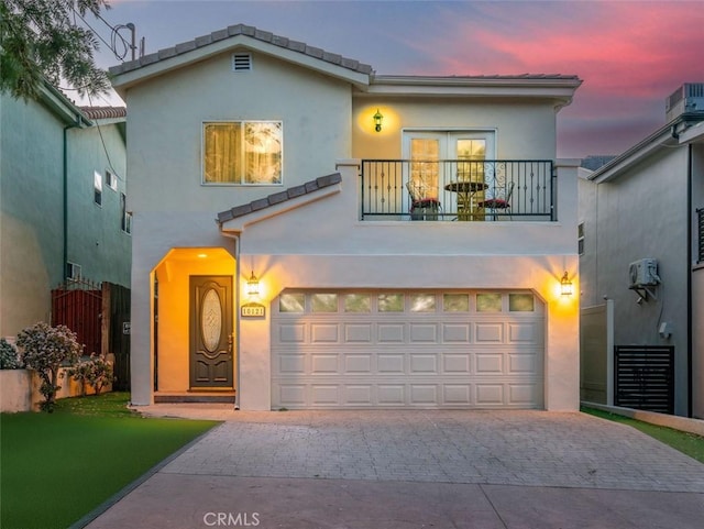 view of front of property featuring a balcony and a garage