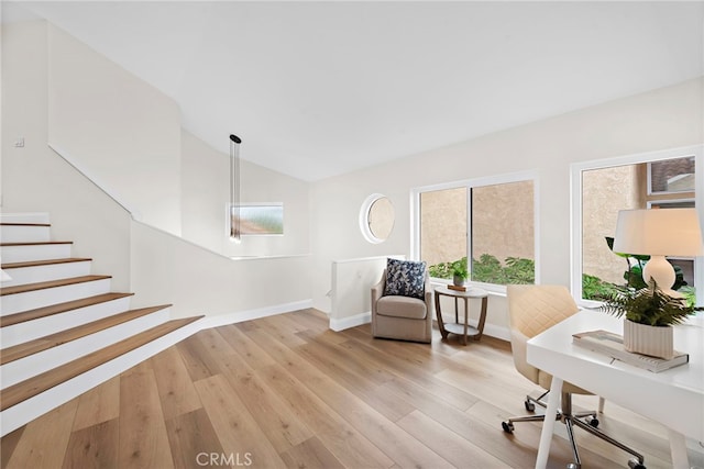 office space featuring lofted ceiling and light hardwood / wood-style flooring