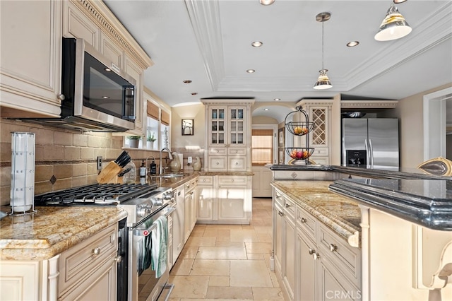 150 Cress St, Laguna Beach, CA 92651 - kitchen featuring stone tile flooring, cream cabinetry, a tray ceiling, appliances with stainless steel finishes, and a sink