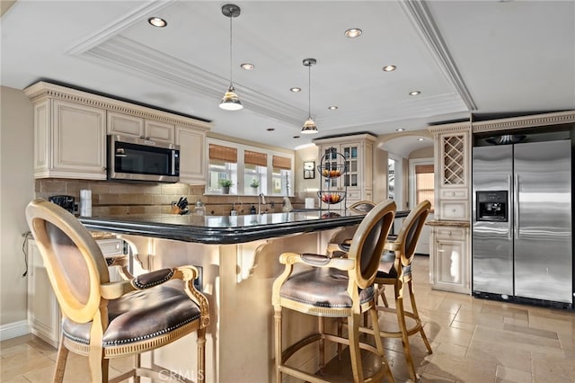 150 Cress St, Laguna Beach, CA 92651 - kitchen with tasteful backsplash, a tray ceiling, cream cabinetry, and appliances with stainless steel finishes