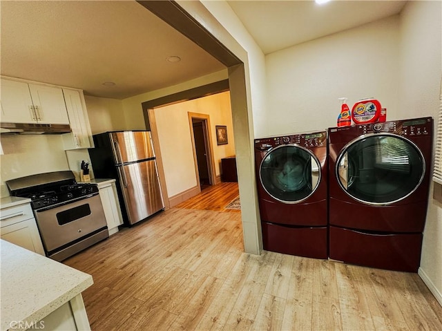 clothes washing area with light hardwood / wood-style floors and independent washer and dryer