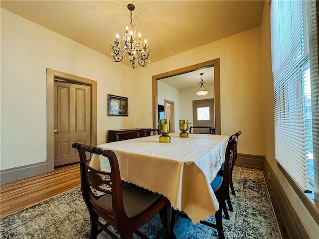 dining area featuring an inviting chandelier and dark wood-type flooring