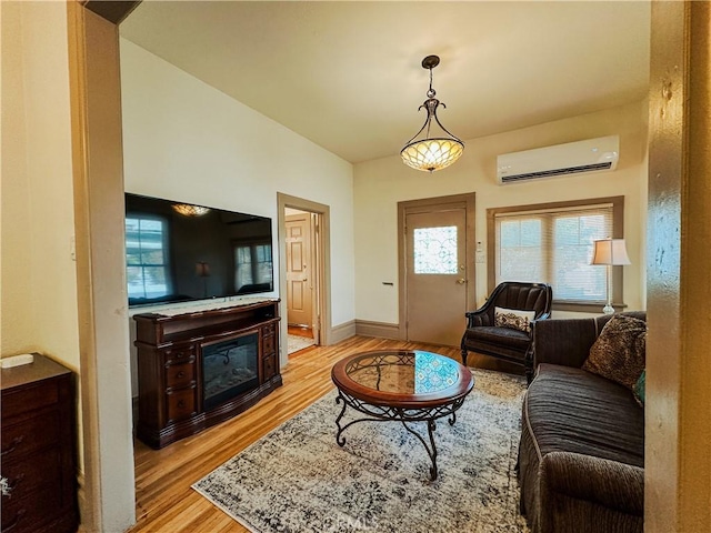 living room with light hardwood / wood-style floors and an AC wall unit