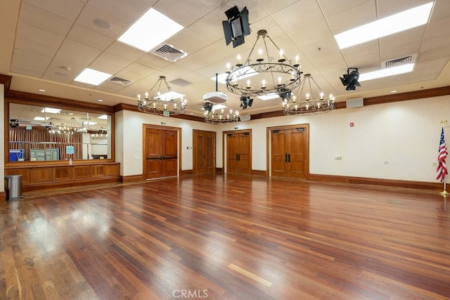 unfurnished room with a chandelier and dark hardwood / wood-style flooring