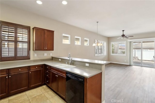 kitchen featuring dishwasher, sink, kitchen peninsula, pendant lighting, and ceiling fan with notable chandelier