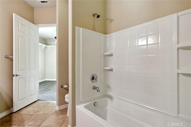 bathroom featuring toilet, tile patterned flooring, and washtub / shower combination