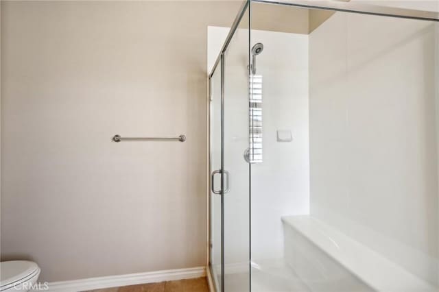 bathroom with toilet and an enclosed shower