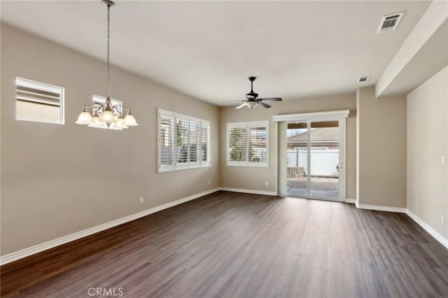 spare room featuring dark wood-type flooring and ceiling fan with notable chandelier