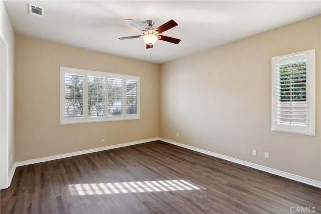 spare room with ceiling fan and dark hardwood / wood-style flooring