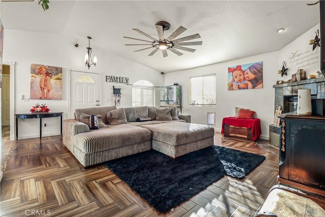 living room featuring vaulted ceiling, ceiling fan, and dark parquet floors