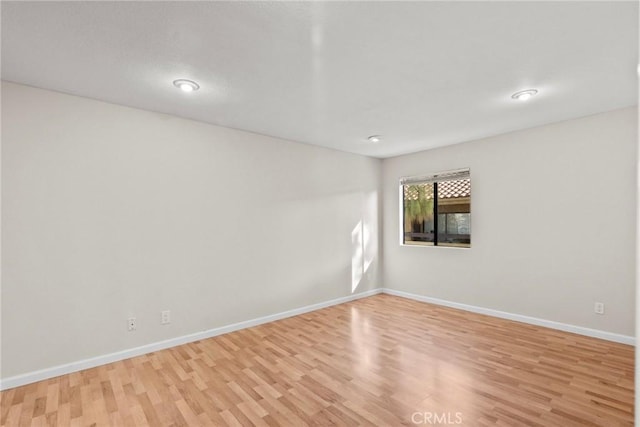 unfurnished room featuring light wood-style floors and baseboards