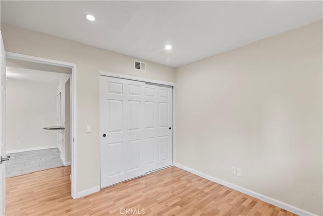 unfurnished bedroom featuring light wood-style flooring, recessed lighting, visible vents, and baseboards