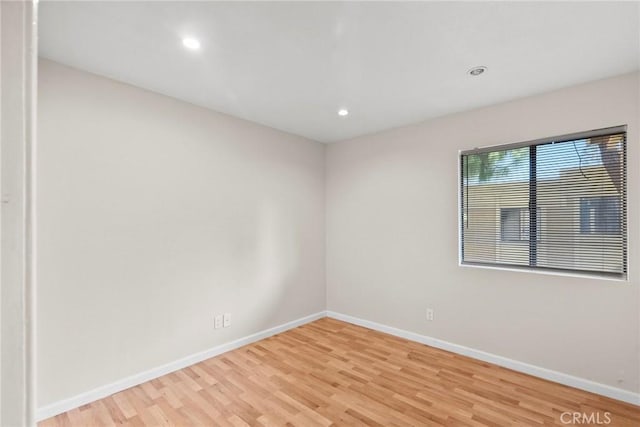 unfurnished room with recessed lighting, light wood-style flooring, and baseboards