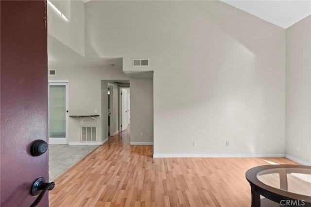 interior space featuring visible vents, light wood-style flooring, and baseboards