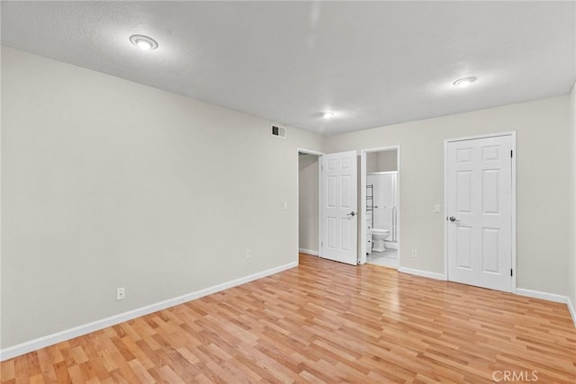 unfurnished room with baseboards, visible vents, and light wood finished floors