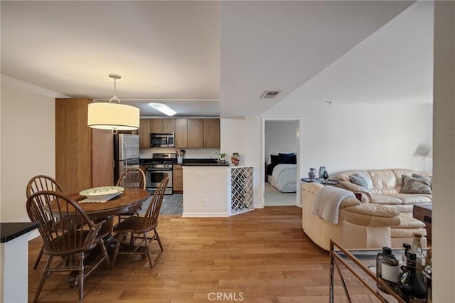 dining room with light wood-type flooring and visible vents