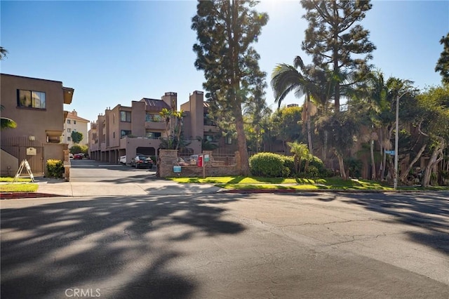 view of road with a residential view, curbs, sidewalks, and street lights